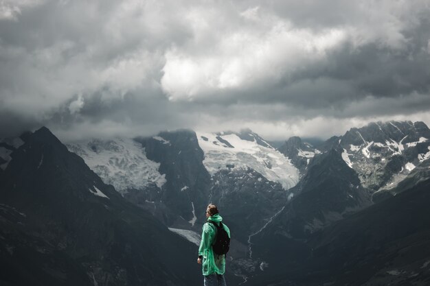 Male traveler and summer mountain stormy landscape