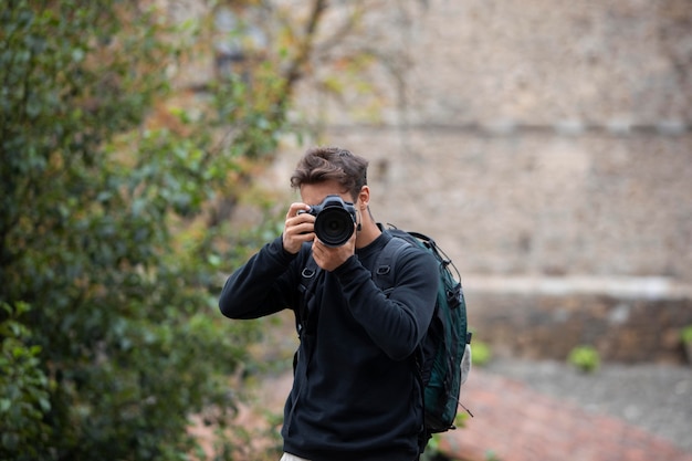 Viaggiatore maschio che utilizza una fotocamera digitale