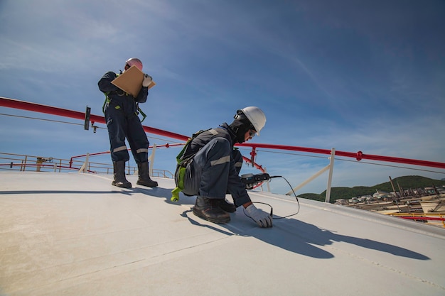 Male two worker are for inspection ultrasonic thickness roof plate dome top of storage tank.