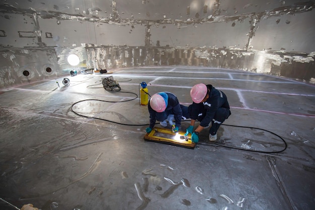 Male two worker inspection vacuum test bottom plate tank glucose syrup steel weld leak internal confined spec