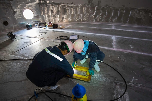 Male two worker inspection vacuum test bottom plate tank glucose syrup steel weld leak