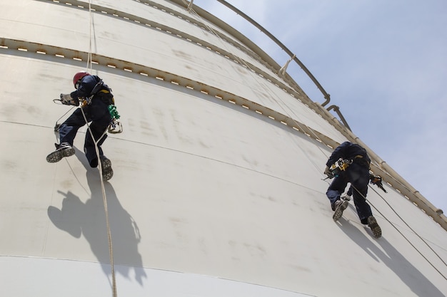 Male two worker rope access  inspection of thickness storage  white tank industry