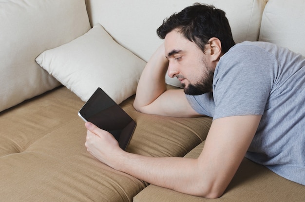 Male using stylus on tablet to draw his ideas at home