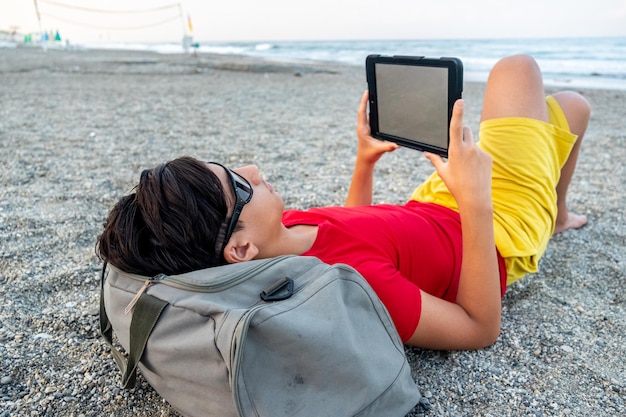 Male using tablet at the beach