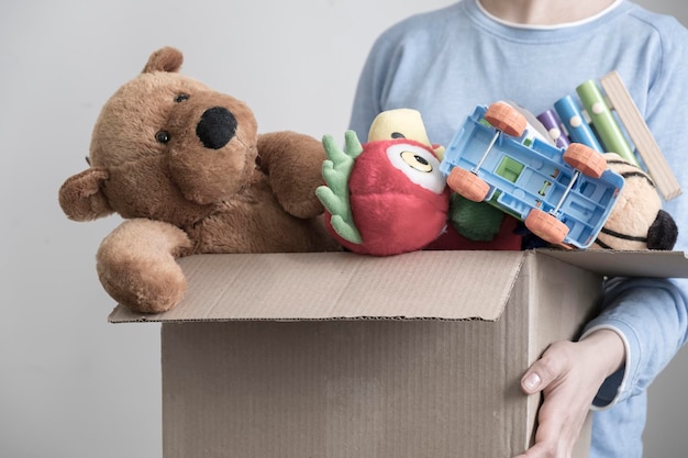 Male volunteer holding donation box with old toys