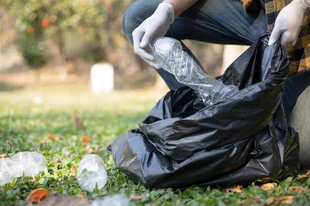 写真 男性ボランティアは公園に落ちた水瓶やプラスチック袋を運びゴミ箱に捨てます