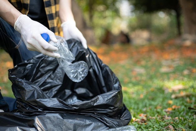 写真 男性ボランティアは公園に落ちた水瓶やプラスチック袋を運びゴミ箱に捨てます