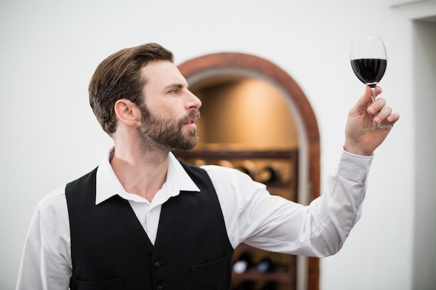 Photo male waiter holding wine glass