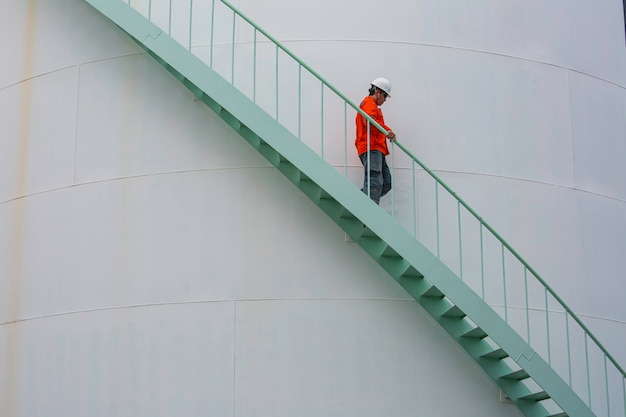 Male walking down the stairway inspection visual storage tank oil