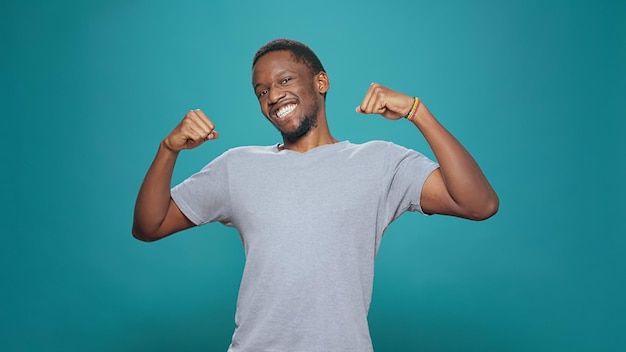 Male winner feeling cheerful about achievement and triumph, celebrating big win and success. Excited person cheering good news and having victory satisfaction, smiling in studio.