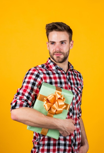 Photo male with fashionable groomed hair and beard hold box, present.
