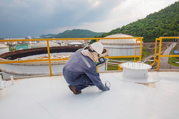 Male worker are for inspection  ultrasonic thickness roof plate top of storage tank