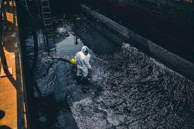 男性労働者がサンプ原油表面のテクスチャ背景を清掃