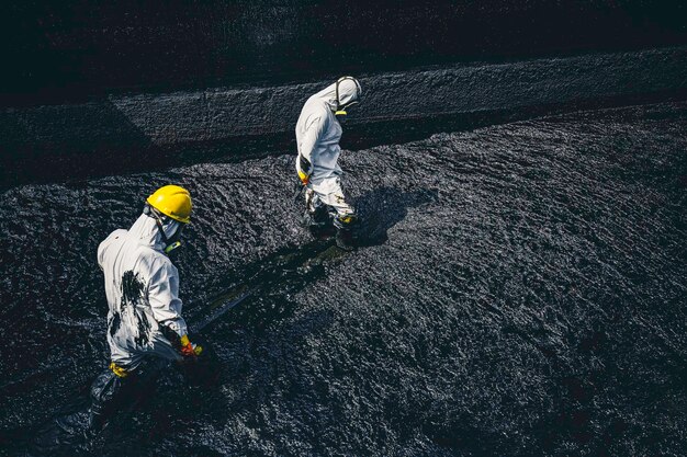 Male worker cleaning sump crude oil surface background