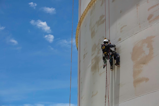 Male worker down height tank roof rope access safety inspection\
thickness weld of storage tank gas