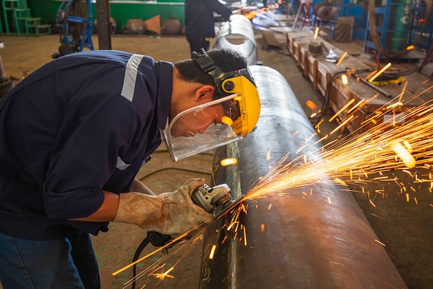 Male worker  grinding on steel plate with flash of sparks close up wear protective gloves