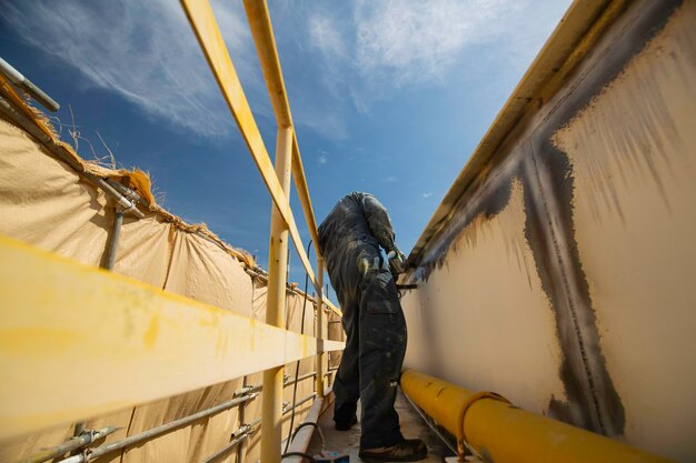 A male worker at high test steel tank butt weld overlay carbon shell plate of storage tank oil