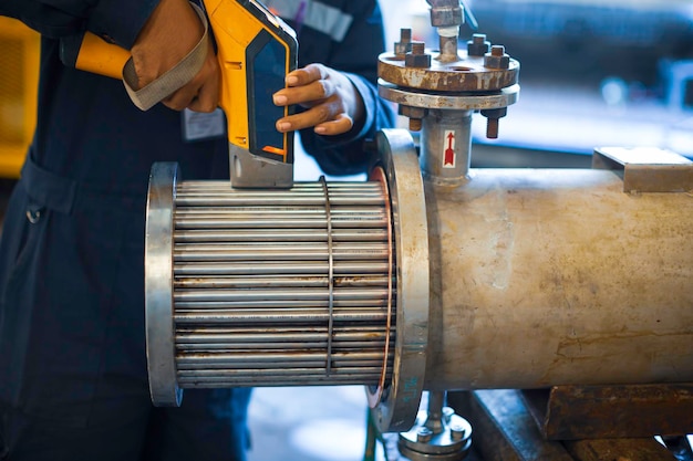 Male worker inspecting surface on heat exchanger tube bundle industrial construction