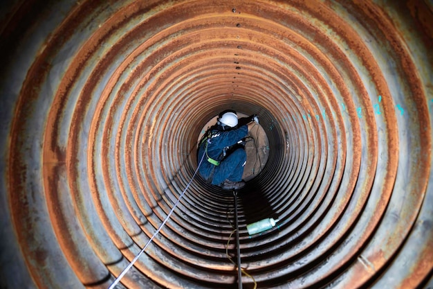 Male worker inspection measured the coil pipe circular thickness of the boiler scan minimum thickness into line rope access symbol dangerous confined