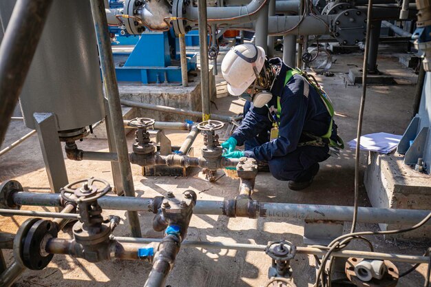 Photo male worker inspection at steel long pipes and pipe elbow in station oil factory during refinery valve of visual check record pipeline