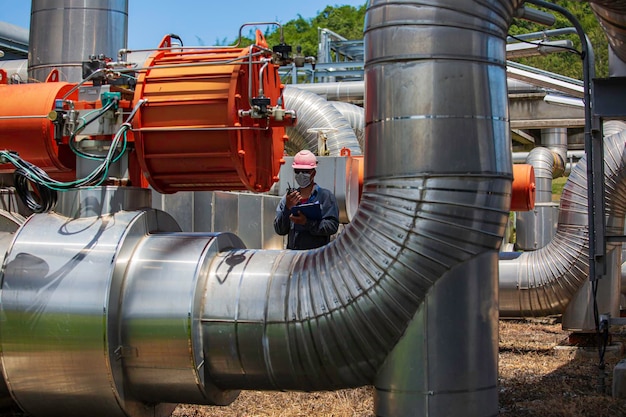 Male worker inspection at steel long pipes and pipe elbow in station oil factory during refinery valve of visual check record pipeline oil and gas