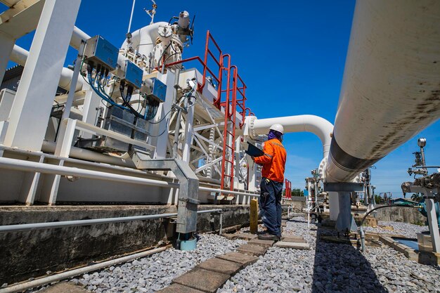 Male worker inspection at steel long pipes and pipe elbow in station oil factory during refinery valve of visual check record pipeline oil