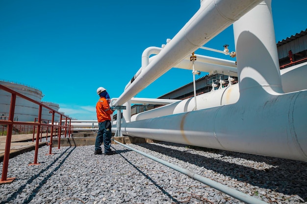 male worker inspection at steel long pipes and pipe elbow in station oil factory during refinery valve of visual check record pipeline oil