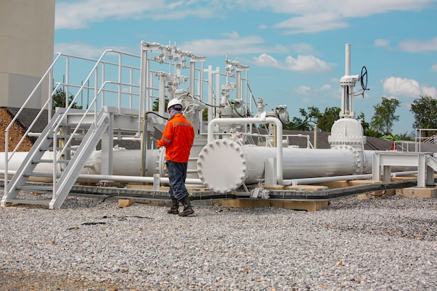 Male worker inspection at steel long pipes and pipe elbow in station oil factory during refinery valve of visual check record pipeline