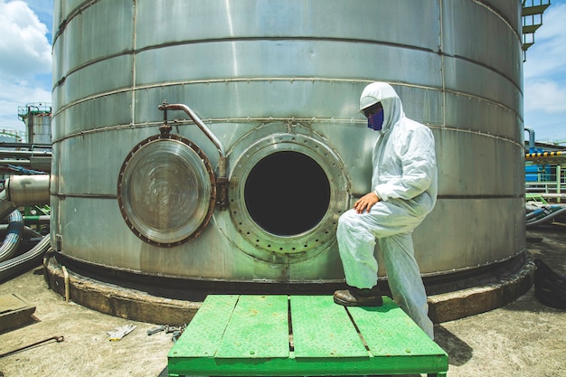 Male worker into  manhole fuel tank oil chemical protective clothing area confined space dangerous