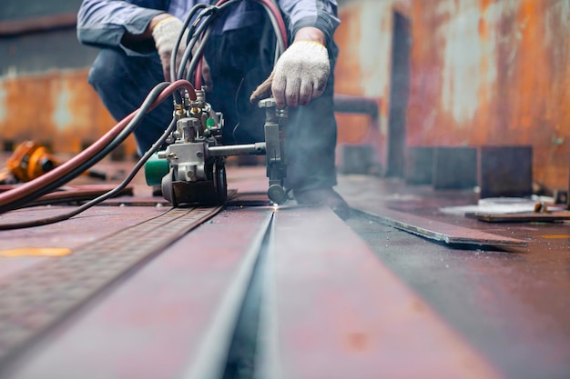 Male worker metal cutting spark on tank bottom steel plate with flash of cutting light close up