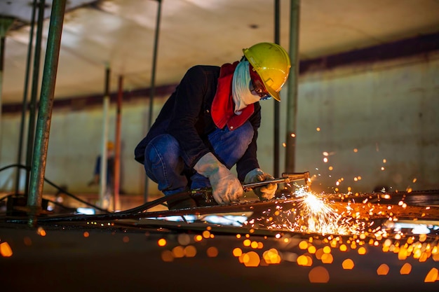 Male worker metal cutting spark on tank bottom steel plate with flash of cutting