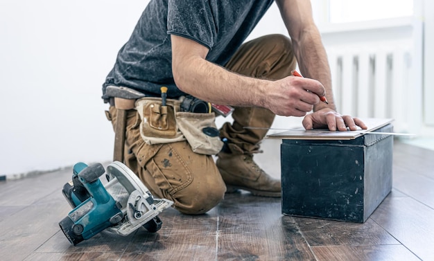 A male worker puts laminate flooring on the floor