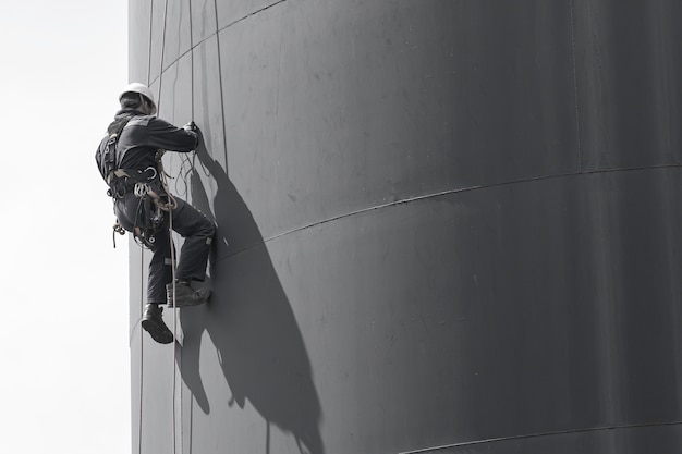 두께 저장 오일 및 가스 탱크 산업의 남성 작업자 로프 접근 높이 안전 검사