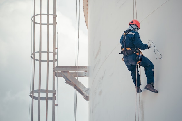 Male worker rope access  inspection of thickness shell plate storage tank industry