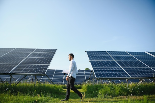 太陽光発電パネルの背景に男性労働者太陽光発電所