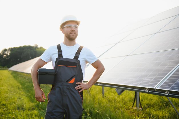 太陽光発電パネルの背景に男性労働者太陽光発電所