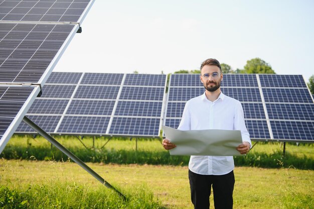 Male worker solar power plant on a background of photovoltaic panels