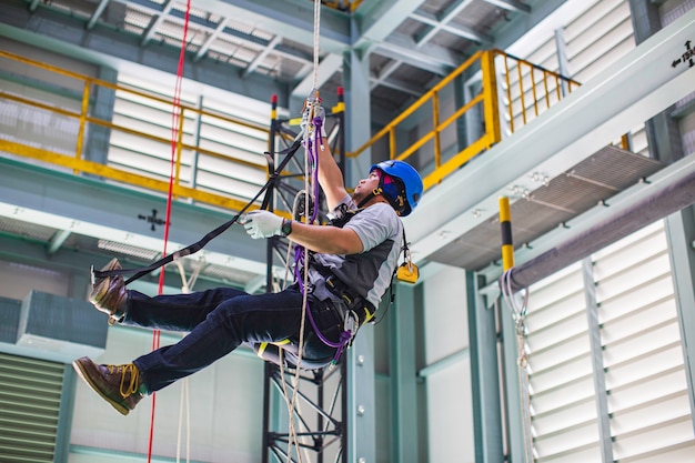 Male worker training rope access in work at high