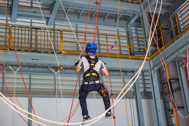 Male worker training rope access in work at high