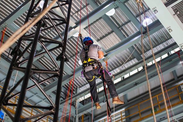 Male worker training rope access in work at high