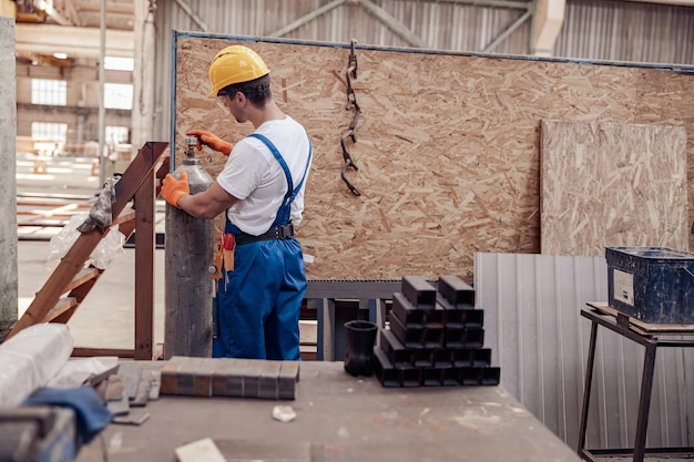 Male worker using gas cylinder in workshop