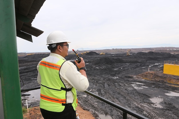 Photo male worker with dump truck in coal mine.