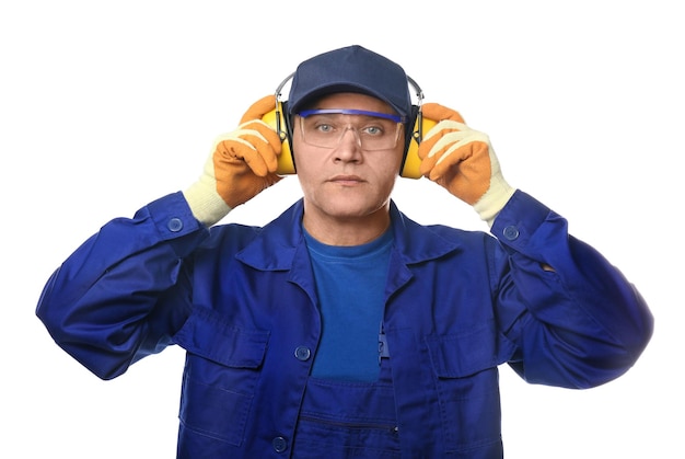 Male worker with hearing protectors and safety goggles on white background