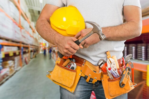 Male worker with tool belt on  background