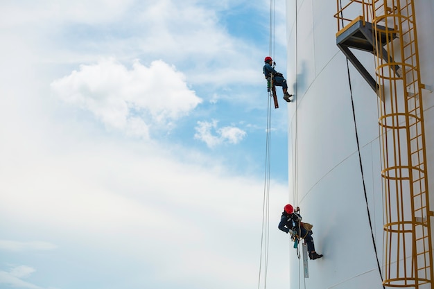 Male workers down height tank rope access inspection of\
thickness shell plate storage tank gas