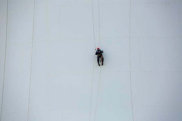 Male workers down height tank rope access inspection of thickness shell plate storage tank