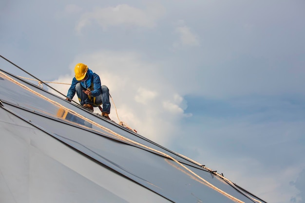 Male workers rope access height safety connecting with a knot\
safety harness, roof fall arrest and fall restraint anchor point\
systems ready to ascending, construction site oil tank dome