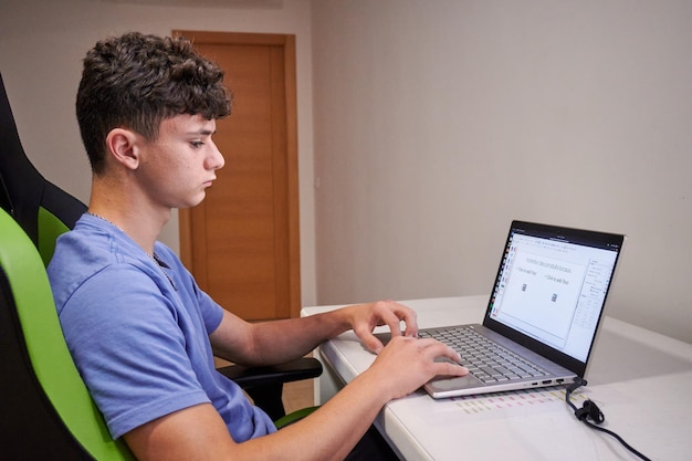 A male working on the laptop on the desk