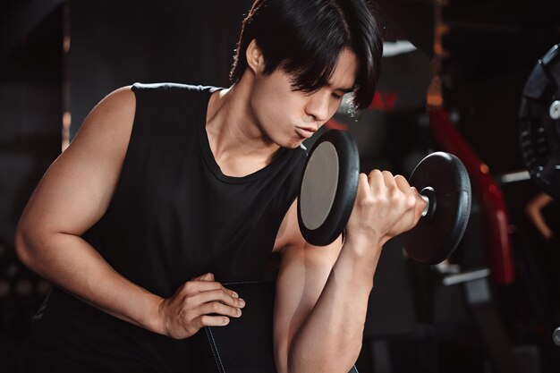 Male working out Bodybuilder with dumbbell weights at the gymman bodybuilder doing exercises with dumbbell