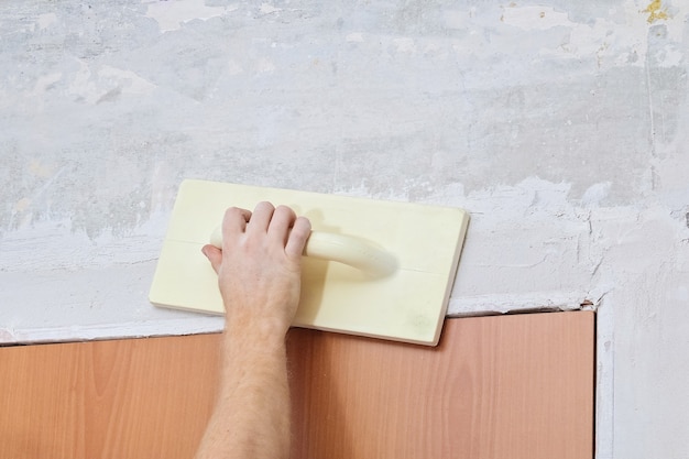 Male working polishes grinds wall